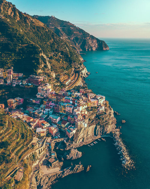 fotografia della scogliera di manarola, con terrazzamenti e casette colorate a picco sul mare