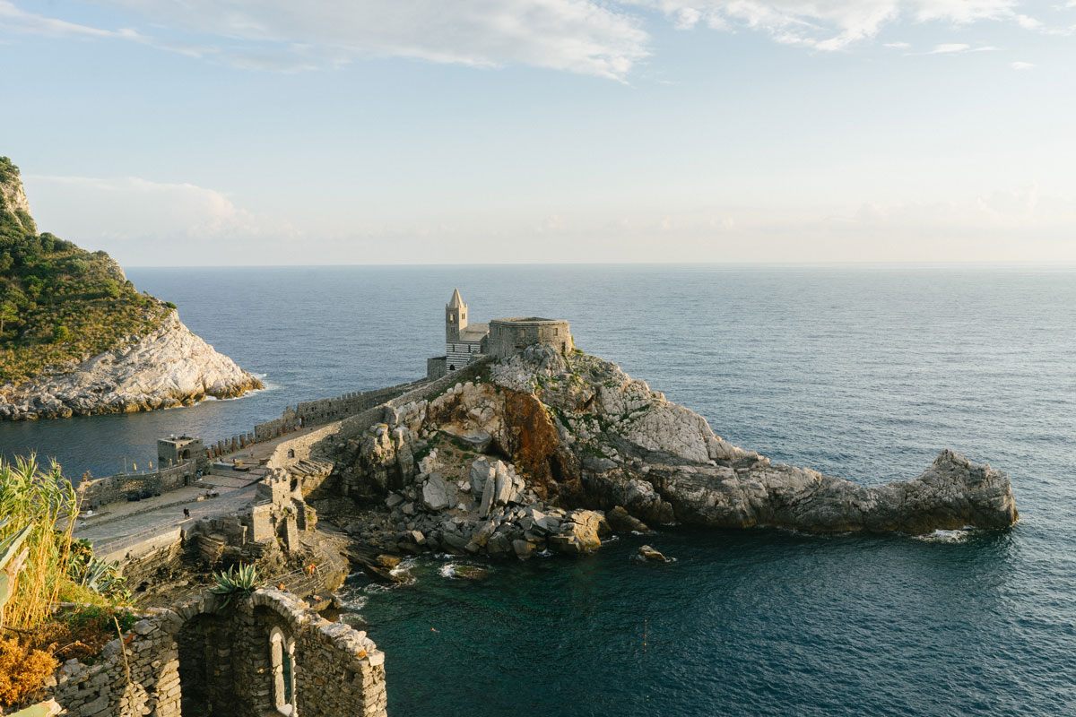 fotografia di un promontorio roccioso circondato dal mare, con in mezzo la chiesa di portovenere